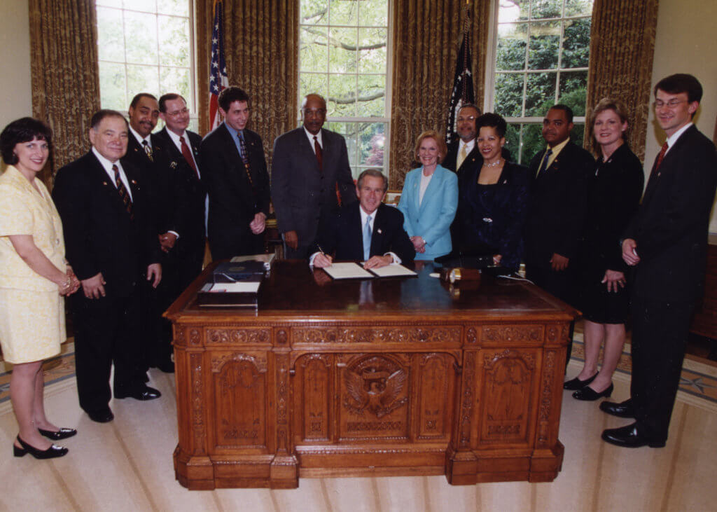 Raul Yzaguirre (second from left) attends a signing by President George W. Bush.